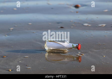 Message in bottle washed onto the sand Stock Photo