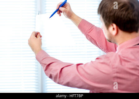 male writing something on transparent paper with marker Stock Photo