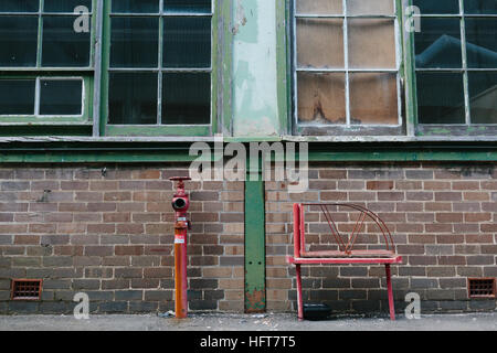 Fire hydrant against a brick wall of an old factory building at Cockatoo Island, formerly Australia's largest shipyard Stock Photo