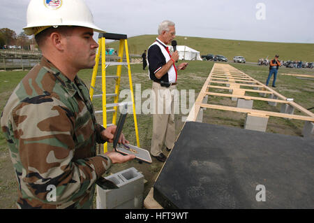 061115-N-4515N-341 Virginia Beach, Va. (Nov. 15, 2006) - Chief Builder Hugh Callahan assigned to Seabee Construction Battalion Maintenance Unit Two Zero Two (CBMU-202), holds the Purple Heart as Meyer Davis, general manager of Kellum funeral home, recites the Purple Heart ceremony before the Purple Heart is placed under the altar of the Dignity Memorial Vietnam Wall. The exhibit crisscrosses the country each year, allowing millions of visitors to see and touch the black, mirror-like surface inscribed with the names of more than 58,000 Americans who died or are missing in Vietnam. The wall hono Stock Photo