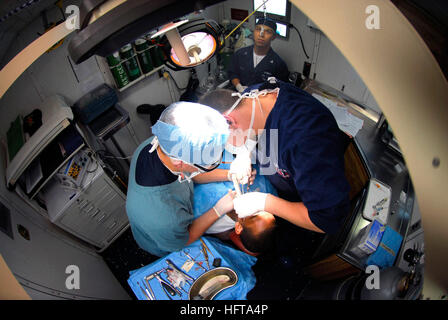 061117-N-6106R-025 Pacific Ocean (Nov. 17, 2006) - Lt. Steve Manzon, from New York City, stitches an oral incision closed on a patient while Hospitalman Alex Johnson, from Jackson, Mississippi, assists. With more than 20 personnel and a full-service clinic, USS Kitty Hawk's (CV 63) Dental Department provides services ranging from oral surgery to preventive services to more than 3,000 Sailors. Kitty Hawk is currently deployed off the coast of southern Japan on a regularly scheduled deployment. U.S. Navy photo by Mass Communication Specialist Seaman Stephen W. Rowe (RELEASED) US Navy 061117-N-61 Stock Photo