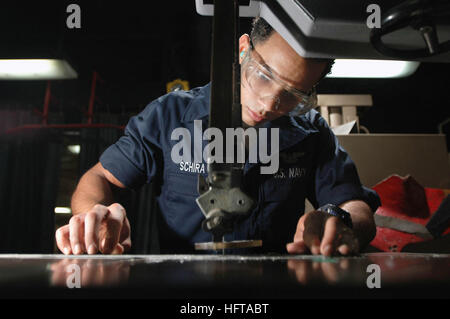 061120-N-1332Y-103 Pacific Ocean (Nov. 20, 2006) - Aviation Structural Mechanic Airman Cesar Schira, from New York City, uses a band saw to fabricate a shelf in the airframes shop on board USS Kitty Hawk (CV 63). The airframes shop repairs and replaces aircraft components supporting Kitty Hawk's nine embarked squadrons. Kitty Hawk, operating out of Fleet Activities Yokosuka, Japan, is currently deployed off the coast of southern Japan on a regularly scheduled deployment. U.S. Navy photo by Mass Communication Specialist Seaman Adam York (RELEASED) US Navy 061120-N-1332Y-103 Aviation Structural  Stock Photo