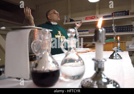 A command chaplain conducts a Roman Catholic mass aboard the aircraft ...