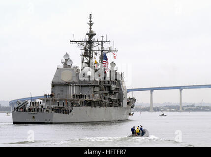 Quarter starboard stern view of the US Navy (USN) TICONDEROGA CLASS: GUIDED MISSILE CRUISER (AGEIS), USS PRINCETON (CG 59) underway in the Harbor at San Diego, California (CA), with ship’s personnel manning the rails as it departs for a deployment in support of Operation ENDURING FREEDOM. A Rigid Hull Inflatable (RHI) port security unit harbor patrol craft is underway in the foreground. USS Princeton (CG-59) departs for OEF 2003 Stock Photo