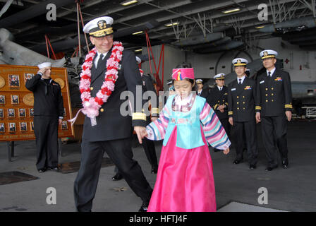 070322-N-3659B-062  BUSAN, South Korea (March 22, 2007) - Commander, Carrier Strike Group (CCSG) 7, Rear Adm. Charles Martoglio escorts a local area child on a visit aboard the Nimitz-class aircraft carrier USS Ronald Reagan (CVN 76) after mooring the ship in Busan, South Korea. Ronald Reagan is conducting a port visit in Busan in conjunction with Exercise Reception, Staging, Onward Movement and Integration/Foal Eagle (RSOI/FE) 2007. U.S. Navy photo by Mass Communication Specialist 2nd Class Joseph M. Buliavac (RELEASED) US Navy 070322-N-3659B-062 Commander, Carrier Strike Group (CCSG) 7, Rear Stock Photo