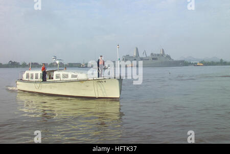 070403-N-0857S-007 NEW ORLEANS, La (April 3, 2007) - A motor-whale boat from Naval Support Activity (NSA) New Orleans prepares to make a morning landing on the East Bank of the Mississippi River. NSA small boat handlers provide valuable a service to Navy personnel, transporting passengers each day between NSAÕs operations on the East and West Banks of the Mississippi River. The recently commissioned amphibious transport dock ship USS New Orleans (LPD 18) is moored in the background. U.S. Navy photo by Sam Shore (RELEASED) US Navy 070403-N-0857S-007 A motor-whale boat from Naval Support Activit Stock Photo