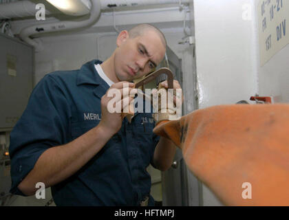 A Seaman Apprentice performs maintenance on a fire hose vari-nozzle aboard USS Dwight D. Eisenhower (CVN 69) during a Maritime Security Operations deployment. Stock Photo