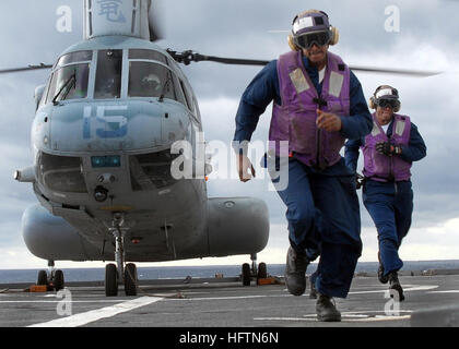 070612-N-5067K-113 PACIFIC OCEAN (June 12, 2007) Ð Aviation Boatswain's Mate (Fuel) Airman Robert D. Cunningham and Aviation Boatswain's Mate (Fuel) Airman Joan R. Abreu hurry as a Marine CH-46 Sea Knight prepares to take off from amphibious transport dock USS Juneau (LPD 10). Juneau is participating in exercise Talisman Saber 2007 (TS07), a U.S. and Australian-led Joint Task Force operation preparing our militaries for crisis action planning and execution of contingency operations. TS07 is designed to maintain a high level of interoperability between U.S. and Australian forces, demonstrating  Stock Photo