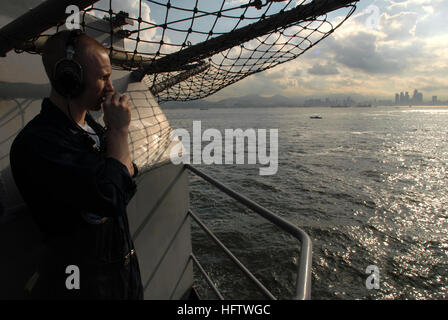 070727-N-3541A-100 SOUTH CHINA SEA (July 27, 2007) - Operations Specialist 3rd Class Charles Shenell performs a phone-check on a sound-powered telephone while standing aft lookout watch on the fantail of the Nimitz-class aircraft carrier USS John C. Stennis (CVN 74) as the ship pulls into Hong Kong harbor. Lookout watches look for ships or other surface contacts that may hinder safe navigation. The John C. Stennis Carrier Strike Group is on a scheduled deployment to promote peace, regional cooperation and stability. U. S. Navy photo by Mass Communication Specialist 2nd Class Davis Anderson (RE Stock Photo