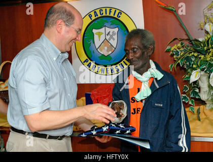 070822-N-1752H-055 BOUGAINVILLE STRAITS (Aug. 22, 2007) - Secretary of the Navy, the Honorable Dr. Donald C. Winter presents Eroni 'Aaron' Kumana with the flag from USS Peleliu (LHA 5) for his courageous efforts more than 60 years ago. During World War II, Kumana rescued Lt. John F. Kennedy, nearly 18 years before becoming president, and his PT-109's crew following the shipÕs collision with a Japanese destroyer near Pudding Island on August 2, 1943. U.S. Navy photo by Mass Communication Specialist Seaman Patrick D. House (RELEASED) US Navy 070822-N-1752H-055 Secretary of the Navy, the Honorabl Stock Photo