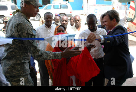 070906-A-1286M-105  BALBALA, Djibouti (Sept. 6, 2007) - Brig. Gen. Sanford Holman, Combined Joint Task Force-Horn of Africa deputy commander and U.S. Ambassador to Djibouti, Stuart Symington assist in cutting a ribbon with a local teacher. The ribbon-cutting ceremony was for the dedication of new classrooms with a stocked library, bathroom facilities, a stage area for plays and power to the Goubetto primary school in the village of Balbala was the focus of a hand-over of the facility to the local community to take care of and preserve. U.S. Army photo by Sgt. Brandon McCarty (RELEASED) US Navy Stock Photo