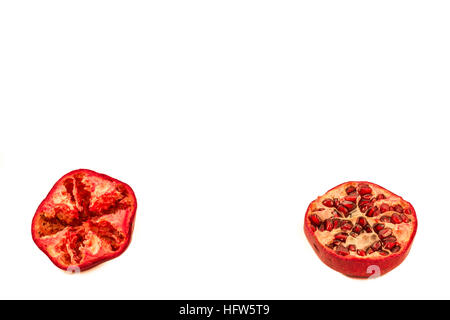 Two halves of pomegranate on a white background one seedless one with seeds Stock Photo