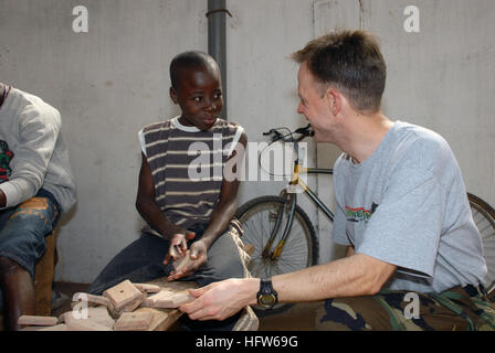 080130-N-0193M-080  LOME, Togo (Jan. 30, 2008) Musician 1st Class Dan Smith, an Africa Partnership Station (APS) volunteer talks with a young boy at Centre d' Accueil Orphanage. APS volunteers and members of Project Handclasp donated toys and hygiene supplies to the children. During the deployment APS will donate more than 150 pallets of food, supplements, medical supplies and hygiene products those in need in West and Central Africa. U.S. Navy photo by Mass Communication Specialist 2nd Class Elizabeth Merriam (Released) US Navy 080130-N-0193M-080 Musician 1st Class Dan Smith, an Africa Partne Stock Photo