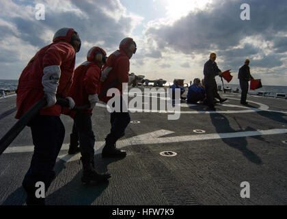 080218-N-5253W-006  PACIFIC OCEAN (Feb. 18, 2008) Sailors aboard the Arleigh Burke-class guided-missile destroyer USS Fitzgerald (DDG 62) man a fire hose and advance towards a simulated helicopter crash on the ship's flight deck during a crash and smash drill. These drills are used to train the crew how to combat fire and rescue personnel in the event of a helicopter crash. Fitzgerald, attached to Destroyer Squadron (DESRON) 15 and permanently forward deployed to Yokosuka, Japan, is underway on a scheduled deployment. U.S. Navy photo by Mass Communication Specialist 3rd Class Gabriel S. Weber  Stock Photo