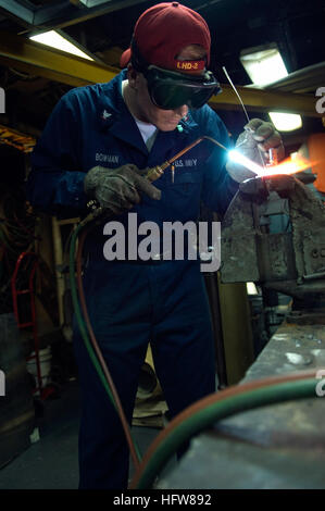 Petty Officer 3rd Class Joshua Bowman, hull technician, assigned to the forward deployed amphibious assault ship USS Essex brazes a component to be used in a manifold for filling water bottles. Essex serves as the flagship for CTF 76, the Navy's only forward deployed amphibious force commander. Working aboard USS Essex DVIDS101428 Stock Photo