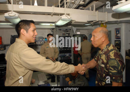 080629-N-7730P-009 PACIFIC (June 29, 2008) Armed Forces of the Philippines, Chief of Staff, Gen. Alexander B. Yano shares a handshake with Lt.j.g. Eduardo Vargas. Gen. Yano flew aboard USS Ronald Reagan (CVN 76) along with the U.S. Ambassador to the Philippines Kristie Kenney to thank the crew for their participation in the Philippine Relief effort. At the request of the government of the Republic of the Philippines, Reagan is off the coast of Panay Island providing humanitarian assistance and disaster response in the wake of Typhoon Fengshen. Reagan and other U.S. Navy ships are operating in  Stock Photo