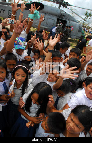080701-N-0640K-305 BALASAN, Philippines (July 1, 2008) Residents from the Municipality of Balasan, Philippines wave and cheer after Sailors assigned to the 'Black Knights' of Helicopter Anti-Submarine Squadron (HS) 4 deliver supplies. The crew has been flying missions to the island delivering food and water to remote cities like Balasan. The Ronald Reagan Carrier Strike Group is off the coast of Panay Island providing humanitarian assistance and disaster response in the wake of Typhoon Fengshen. The region was hard-hit by Typhoon Fengshen and the ÒBlack KnightsÓ have been flying seven straight Stock Photo