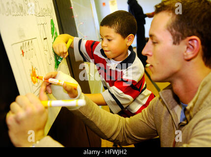 081210-N-5345W-018 VIRGINIA BEACH, Va. (Dec. 10, 2008) Aviation Electronics Technician 3rd Class Ryan Forde colors a holiday poster alongside his mentee during a Christmas party at Windsor Oaks Elementary School. Forde, along with several other Sailors assigned to Naval Air Station Oceana Command Fleet Readiness Center Mid-Atlantic, participated in a mentorship program with the students at Windsor Oaks throughout the year. (U.S. Navy photo by Mass Communication Specialist 2nd Class Kristopher S. Wilson/Released) US Navy 081210-N-5345W-018 Aviation Electronics Technician 3rd Class Ryan Forde co Stock Photo