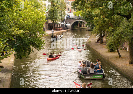 Utrecht Netherlands. Utrecht Oude Gracht Canal with kayaks, electric boat and gondola. Typical for Utrecht Canals are the wharfs. Stock Photo