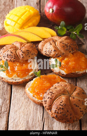 Sweet sandwiches with mango jam, butter and mint close-up on the table. vertical Stock Photo
