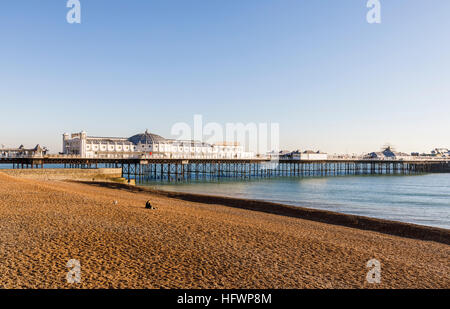 The Victorian Brighton Palace Pier and shingle Brighton beach deserted on a sunny winter day in November with blue sky Stock Photo