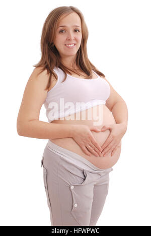 Pregnant woman clasped her hands in the shape of a heart on grey background Stock Photo