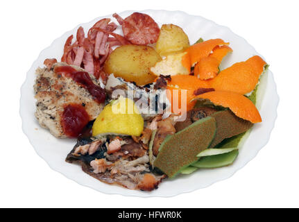 On a white plate - food scraps from a New Year's holiday table. Isolated concept Stock Photo