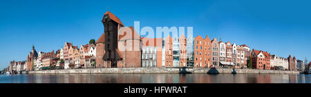 Gdansk old city in Poland. Wide panorama with the oldest medieval port crane (Zuraw) in Europe, and the quay along the riverbank of Motlawa River. Stock Photo