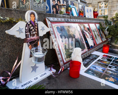 Munich, Germany - 29 December 2016: Votive candles, pictures and memorabilia of the late pop star Michael Jackson, placed by his fans at the so called 'Michael Jackson Memorial' at Munich's Promenadeplatz across the hotel 'Bayerischer Hof'. Since the death of the artist in 2009, the historic stone monument of Orlando di Lasso has been converted into a shrine and memorial by fans of the 'King of Pop' who used to occupy a suite at the nearby luxury hotel when staying in Munich. Stock Photo