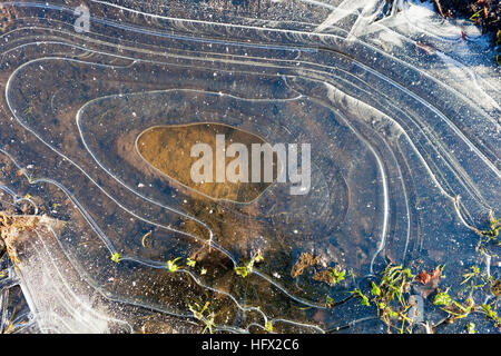 Abstract background with patterns, shapes and textures of a frozen puddle in winter Stock Photo
