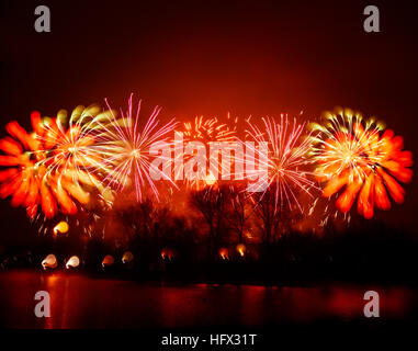 Abstract, blurry, bokeh-style colorful photo of fireworks above the river in New Year Stock Photo