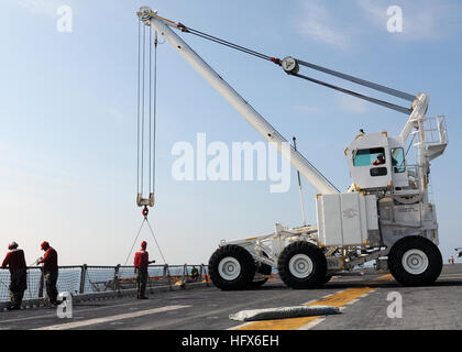 100712-N-2908M-002  ATLANTIC OCEAN (July 12, 2010) Crash and Salvage division crew members aboard the amphibious assault ship USS Kearsarge (LHD 3) direct an aircraft crash crane while storing a loading ramp.  The Kearsarge Amphibious Ready Group (ARG) is participating in a Composite Unit Training Exercise (COMPTUEX) off the East Coast of the United States. (U.S. Navy photo by Mass Communication Specialist 3rd Class Joshua Mann/Released) US Navy 100712-N-2908M-002 Crash and salvage team stores loading ramp Stock Photo