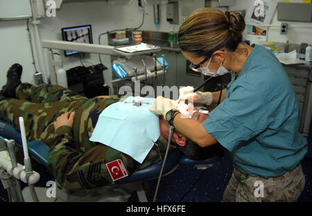 090313-N-9761H-007 PERSIAN GULF (March 13, 2009) Lt. Angela Roldan-Whittaker, dental officer for the 13th Marine Expeditionary Unit embarked aboard the amphibious assault ship USS Boxer (LHD 4), provides a routine dental cleaning for a Turkish master chief petty officer assigned to the Turkish Naval Forces ship TCG Giresun. Boxer is deployed as part of Boxer Amphibious Readiness Group/13th Marine Expeditionary Unit supporting maritime security operations in the U.S. 5th Fleet area of responsibility. (U.S. Navy photo by Mass Communication Specialist 2nd Class Jeff Hopkins/Released) US Navy 0903 Stock Photo