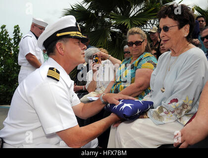 090408-N-9758L-087 PEARL HARBOR, Hawaii (April 8, 2009) Capt. Douglas Waite, command chaplain for commander, Navy Region Hawaii and Naval Surface Group Middle Pacific, hands a folded American flag to the wife of Pearl Harbor survivor retired Capt. Demetrius Vellis was stationed aboard the destroyer USS Dale (DD 353) during the Dec. 7, 1941 attack on Pearl Harbor. More than 50 friends and family members paid their respects by dropping flower petals off the edge of the memorial. (U.S. Navy photo by Mass Communication Specialist 2nd Class Michael A. Lantron/Released) US Navy 090408-N-9758L-087 Ca Stock Photo