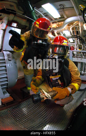 050716-N-1693W-075 Western Pacific Ocean (July 16, 2005) - The hose team leader from Repair Locker 3, tells his number one nozzleman the proper technique to set a re-flash watch during a class Bravo fire drill in the engine room aboard the command ship USS Blue Ridge (LCC 19). The shipÕs fire fighting teams are practicing main space fire drills in preparation for upcoming main space certification.  Blue Ridge, the U.S. Navy's only permanently forward deployed command ship, operates from Yokosuka, Japan. U.S. Navy photo by PhotographerÕs US Navy 050716-N-1693W-075 The hose team leader from Repa Stock Photo