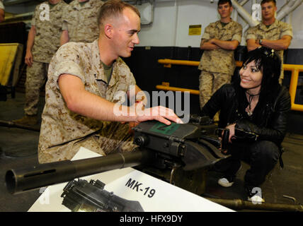 090518-N-3595W-321 ATLANTIC OCEAN (May, 19 2009) Lance Cpl. Sean Godfrey, assigned to the 26th Weapons Company, based at Camp Lejeune, N.C., gives Joan Jett, lead singer of Joan Jett and the Blackhearts, an overview of the MK-19 40mm machine gun during a tour of the amphibious assault ship USS Iwo Jima (LHD 7). Iwo Jima is en route to Fleet Week New York City 2009. This week-long event provides an opportunity for the citizens of New York and the surrounding tri-state area to meet Sailors, Marines and Coast Guardsmen, as well as see first-hand the latest capabilities of today's maritime service Stock Photo