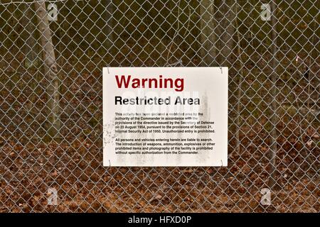 A restricted area sign on the outside of a US Army installation fence Stock Photo