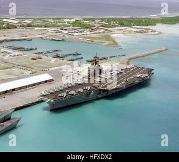 An aerial port bow view of the aircraft carrier USS SARATOGA (CV-60) tied up at pier.  This is the first time an aircraft carrier has visited the island. USS Saratoga (CV-60) moored December 1985 Stock Photo