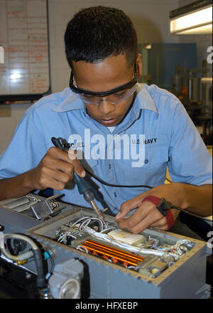Aviation Electronics Technician performs maintenance on a power supply at Aviation Intermediate Maintenance Department (AIMD) on board Naval Air Station Jacksonville, ensuring equipment reliability and operational readiness. Stock Photo