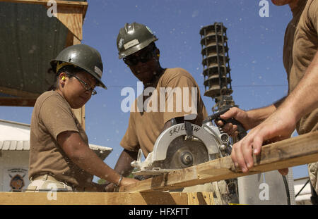 Constructionmen Aurora Bahr, Tyrone Huffin and Chad Smith cut wood that will be used to make flooring for new buildings, Naval Mobile Construction Battalion 3, Camp Lemonier, Djibouti, Nov. 8, 2005. The two new buildings will be used to combine and house the Joint Task Force-Horn of Africa's Future Operations personnel, who are currently separated in different work tents. (RELEASED) (U.S. Air Force photo by Staff Sgt. Stacy L. Pearsall) US Navy 051108-F-7234P-043 U.S. Navy Constructionmen Aurora Bahr, Tyrone Huffin, and Chad Smith, all assigned to Naval Mobile Construction Battalion Three (NMC Stock Photo