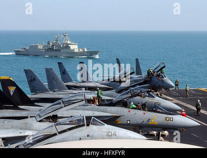 051111-N-0685C-002 Persian Gulf (Nov. 11, 2005) Ð Squadron personnel ready their squadronÕ F-14D Tomcats for flight operations on the flight deck of the Nimitz-class aircraft carrier USS Theodore Roosevelt (CVN 71), as the Royal Australian Navy frigate HMAS Parramatta, sails closely behind. Roosevelt and embarked Carrier Air Wing Eight (CVW-8) are currently underway in the Persian Gulf supporting Operation Steel Curtain, an offensive aimed at preventing cells of Al Qaeda from entering Iraq through the Syrian border. U.S. Navy photo by Photographer's Mate Airman Javier Capella (RELEASED) US Nav Stock Photo