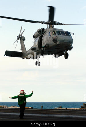 051117-N-8163B-006 Persian Gulf (Nov. 17, 2005) – A Landing Signal Enlisted directs an SH-60F Seahawk helicopter, assigned to the 'Tridents' of Anti-Submarine Squadron Three (HS-3), to landing aboard the Nimitz-class aircraft carrier USS Theodore Roosevelt (CVN 71). Roosevelt and embarked Carrier Air Wing Eight (CVW-8) are currently underway in the Persian Gulf supporting Operation Steel Curtain, a joint U.S.-Iraqi military offensive aimed at preventing cells of Al Qaeda from entering Iraq through the Syrian border. U.S. Navy photo by Photographer's Mate Airman Eben Boothby (RELEASED) US Navy  Stock Photo