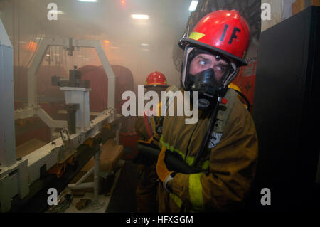 051129-N-8604L-176 Pacific Ocean (Nov. 29, 2005) Ð A Sailor assigned to Repair Locker 1 Foxtrot relays a message from the hose team leader while combating a simulated fire in the jet engine shop during a general quarters (GQ) drill aboard the conventionally powered aircraft carrier USS Kitty Hawk (CV 63). Kitty Hawk and embarked Carrier Air Wing Five (CVW-5) are currently conducting operations in the Western Pacific Ocean. U.S. Navy photo by Photographer's Mate Airman Joshua Wayne LeGrand (RELEASED) US Navy 051129-N-8604L-176 A Sailor assigned to Repair Locker 1 Foxtrot relays a message from t Stock Photo