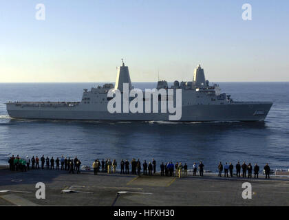 051210-N-7359L-001 Atlantic Ocean (Dec. 10, 2005) - Sailors aboard the Nimitz-class aircraft carrier USS Dwight D. Eisenhower (CVN 69) gather on the flight deck to watch as the amphibious transport dock USS San Antonio (LPD 17) sails alongside. San Antonio is the lead ship in the NavyÕs newest amphibious transport dock-class of ships. She is scheduled to arrive in her new homeport of Naval Station Norfolk, Va., for the holidays and then will sail to Ingleside, Texas for her commissioning ceremony, Jan. 14, 2006. U.S. Navy photo by Photographer's Mate 3rd Class Christopher B. Long (RELEASED) US Stock Photo