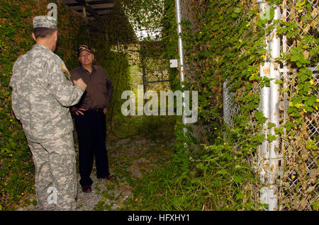 060108-N-2568S-047 Guantanamo Bay, Cuba (Jan. 8, 2006) - Led by Joint Task Force Guantanamo Commanding General, Maj. Gen. Jay Hood, Secretary of the Navy (SECNAV), Dr. Donald C. Winter, inspects the heavily overgrown remains of Camp X-ray. This is the original site used to temporarily house enemy combatants being held at Guantanamo. Currently, enemy combatants are held in more modern facilities, which according to Maj. Gen. Hood, meet or exceed the standards set for prison facilities in the United States. Camp X-ray was used for 4 months and permanently closed in April of 2002. U.S. Navy photo Stock Photo