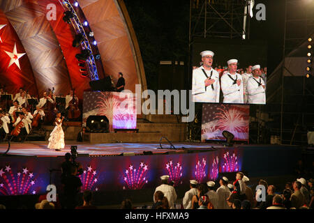 090704-N-3271W-163 BOSTON, Mass. (July 4, 2009) Three local sailors sing ÒThe Star-Spangled BannerÓ with Oladunni Oladipo during the opening ceremony of the annual Boston Pops Fireworks Spectacular at the Charles River Esplanade. The nationally broadcast performance by the famous orchestra was the finale of scheduled events during Boston Harborfest and Boston Navy Week. Navy Weeks are designed to show Americans the investment they have made in their Navy and increase awareness in cities that do not have a significant Navy presence. (U.S. Navy photo by Senior Chief Mass Communication Specialist Stock Photo