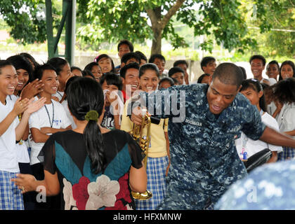 101014-N-7783B-035 SAN MIGUEL, Philippines (Oct. 14, 2010) U.S. Navy Musician 3rd Class Michael Bookman, assigned to the U.S. 7th Fleet Band, Orient Express, dances with students at San Miguel National High School during a Cooperation Afloat Readiness and Training (CARAT) Philippines community service project. CARAT is a series of bilateral exercises held annually in Southeast Asia to strengthen relationships and promote maritime security. (U.S. Navy photo by Mass Communication Specialist 1st Class Thomas J. Brennan/Released) US Navy 101014-N-7783B-035 U.S. Navy Musician 3rd Class Michael Book Stock Photo