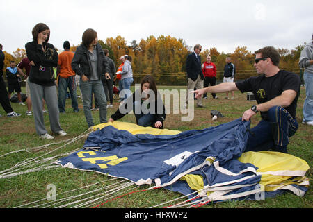 091029-N-5366K-012 EDGEWATER, Md. (Oct. 29, 2009) Chief Special Warfare Operator (SEAL) Justin Gauny, assigned to the U.S. Navy Parachute Team, the Leap Frogs, shows students how to pack his parachute after the team gave a demonstration at South River High School. The team jumped before the start of the Anne Arundel County Cross Country Championship to raise awareness about Naval Special Warfare. The Leap Frogs are based in San Diego and perform freefall parachuting demonstrations across the United States. (U.S. Navy photo by Mass Communication Specialist 2nd Class Michelle Kapica/Released) US Stock Photo