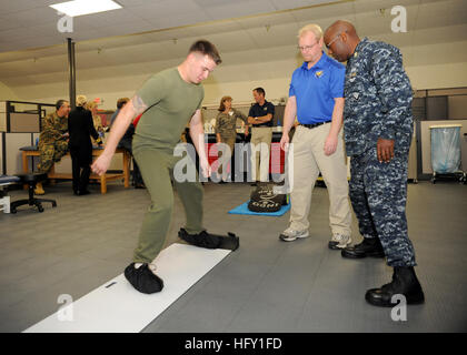 100201-N-6326B-093 SAN DIEGO (Feb. 1, 2009) Athletic trainer Brett E. Weaver and Master Chief Hospital Corpsman Rodney Taylor, senior enlisted leader for the Director of Branch Clinics, watch as Marine Lance Cpl. Michael G. Sanders uses a slide board to strengthen his legs during the official opening of the Sports Medicine and Rehabilitation Therapy Clinic at Marine Corps Air Station Miramar. The clinic helps Sailors and Marines return to full duty after sustaining musculoskeletal injuries. (U.S. Navy photo by Mass Communication Specialist 3rd Class Jake Berenguer/Released) US Navy 100201-N-63 Stock Photo