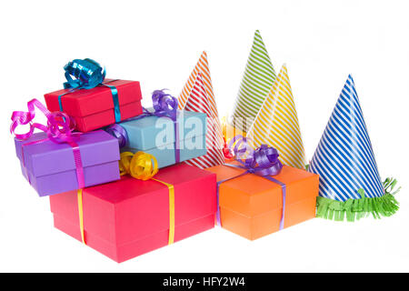 colorful present boxes with ribbon stacked asymetrically and randomly with party hats next to them isolated on white background Stock Photo